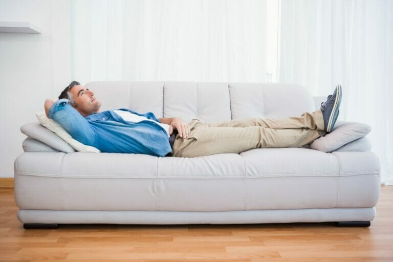 man lying on a sofa, relaxed in a comfortable environment.
